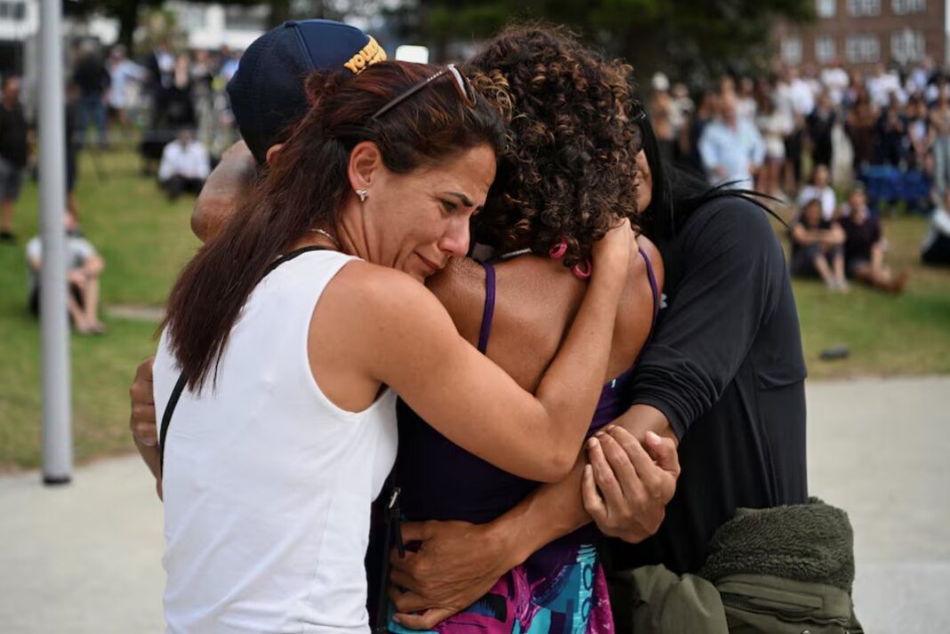 People embrace as they visit a makeshift memorial following the attack on a Jewish holiday celebration at Sydney's Bondi Beach, in Sydney, Australia, December 15, 2025.