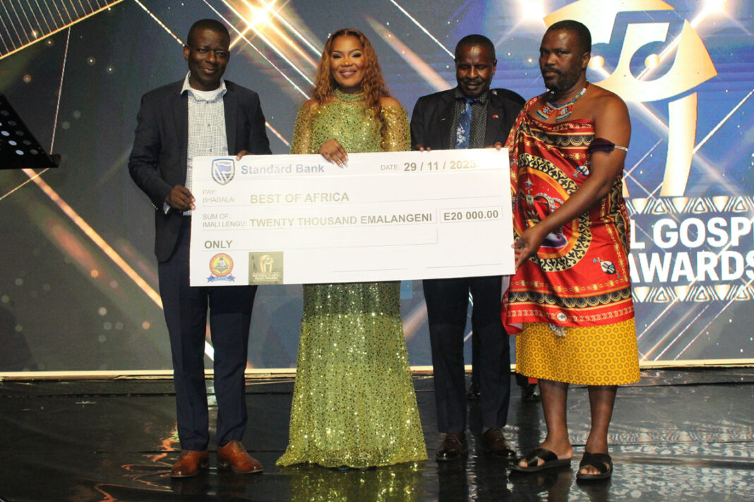 PM’s representative Minister of Tinkhundla Sikhumbuzo Dlamini hands over the E20 000 replica cheque to Nothando Hlophe who was flanked by Minister Bongani Nzima and Kumethula MP Jabulani Simelane.